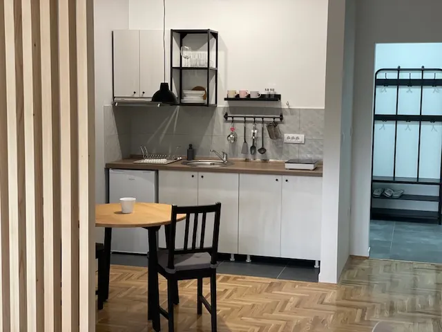 Kuhinja apartmana sa trpezarijskim stolom i drvenom pregradom